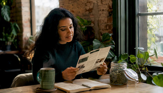 Woman researching UK herbal wellness brands at kitchen table